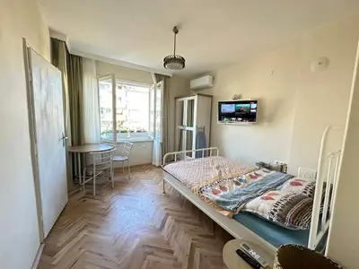 a small bedroom with a bed and a table at Something In French in Burgas City