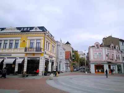a city street with buildings and people walking on the street at Apartment Alegria in Varna City