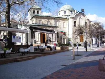 an old building with a table and chairs on a street at Apartment Alegria in Varna City