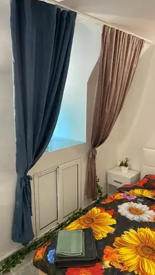 a bedroom with a bed and a window with a laptop on it at Sunrise Sea Garden in Burgas City