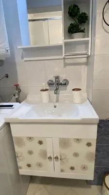 a white bathroom sink with two cups on it at Sunrise Sea Garden in Burgas City