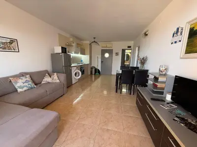 a living room with a couch and a dining room at White Pearl Apartment Sozopol in Sozopol
