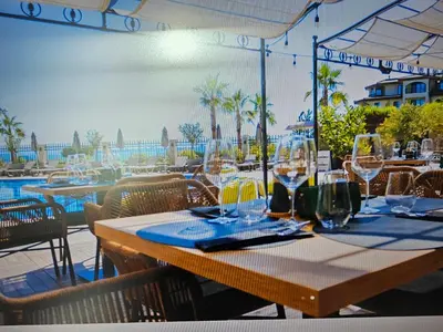 a table with wine glasses on top of a restaurant at Zerini Apartment in Burgas City