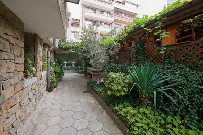 a garden with a stone wall and a walkway at Apartment Dora in Pomorie