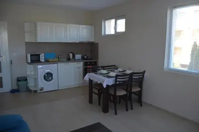 a kitchen with a table and chairs and a kitchen with a washing machine at Divela 3 Apartments in Nesebar