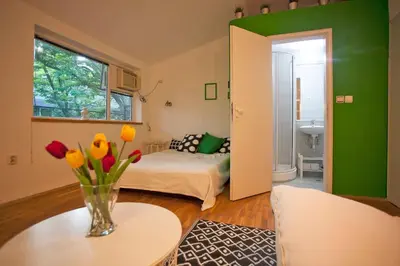 a room with a bed and a vase of flowers on a table at Varna Heart Studio in Varna City