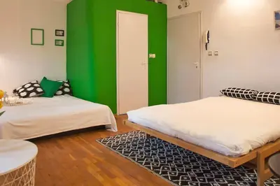 two beds in a room with a green wall at Varna Heart Studio in Varna City