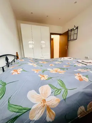 a bedroom with a bed with flowers on it at Deluxe Apartment Burgas City Centre with Free Parking in Burgas City