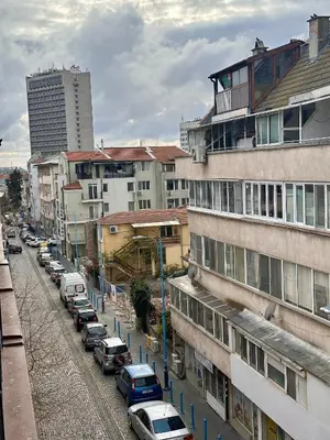 a row of cars parked on a street with buildings at Deluxe Apartment Burgas City Centre with Free Parking in Burgas City