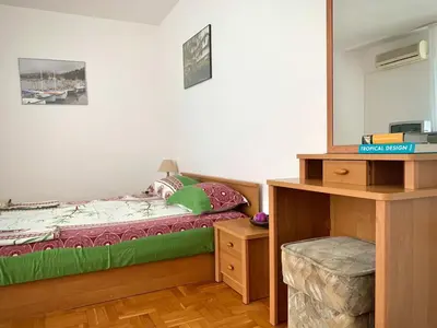 a bedroom with a bed and a dresser and a mirror at Тедис хоум in Burgas City