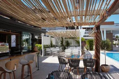 a patio with a table and chairs and a pool at Apolonia Resort in Sozopol