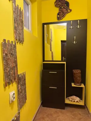 a bathroom with a mirror and a yellow wall at The Central Studio in Burgas City
