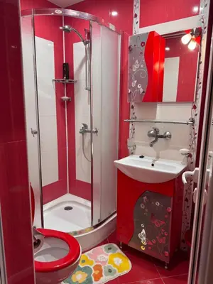 a red bathroom with a shower and a toilet at The Central Studio in Burgas City