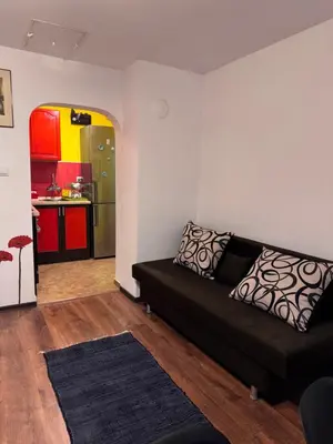 a living room with a black couch and a kitchen at The Central Studio in Burgas City
