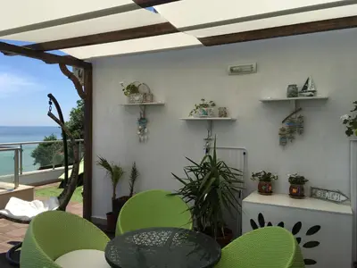 a patio with a table and chairs and the ocean at HPManagement Byala Beach Residence Apartments in Byala