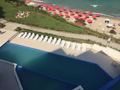 an overhead view of a swimming pool with umbrellas and a beach at HPManagement Byala Beach Residence Apartments in Byala