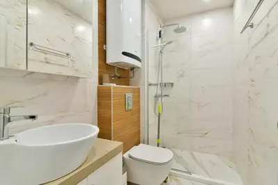 a bathroom with a sink and a toilet and a shower at Super central cozy flat in Varna City