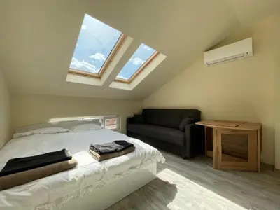 a bedroom with a bed and a couch and windows at Varna Centre Apartment 2 in Varna City