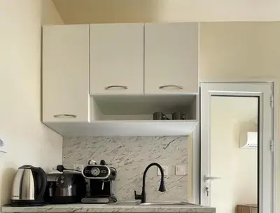 a kitchen with white cabinets and a sink with a tea kettle at Varna Centre Apartment 2 in Varna City