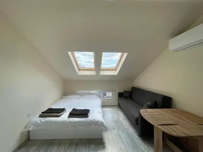a bedroom with a bed and a couch and a window at Varna Centre Apartment 2 in Varna City