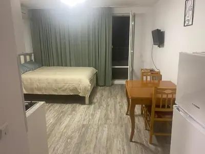 a small room with a bed and a desk and a table at Краун Форт in Sveti Vlas
