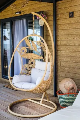 a wicker swing chair hanging on a porch at Black Sea Villas Fichoza in Varna City
