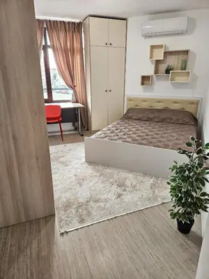 a bedroom with a bed and a red chair and a desk at FOUR SEASONS Beach Apartment in Pomorie
