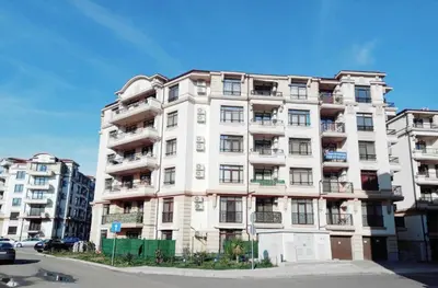 a tall white building on the corner of a street at FOUR SEASONS Beach Apartment in Pomorie