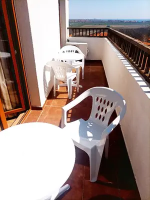 a balcony with white chairs and tables on a building at Vineyard Spa Resort 2-Room Apartement in Kableshkovo