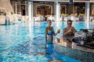 a man and a girl in a swimming pool at Vineyard Spa Resort 2-Room Apartement in Kableshkovo