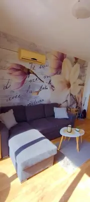 a living room with a purple couch and a flower mural at Vineyard Spa Resort 2-Room Apartement in Kableshkovo