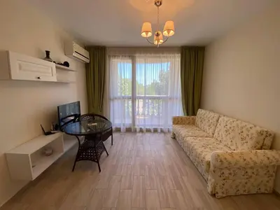 a living room with a couch and a table at Апартамент Cascadas in Sunny Beach