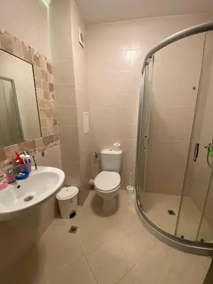 a bathroom with a toilet and a sink and a shower at Апартамент Cascadas in Sunny Beach