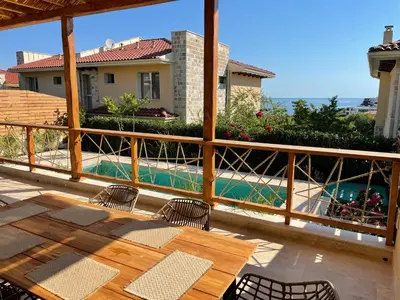 a patio with a table and chairs and a pool at Coral Bay Luxury Villa by Lozenets Luxury Villas in Lozenets
