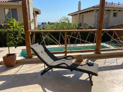 a chair with a hat sitting on a patio at Coral Bay Luxury Villa by Lozenets Luxury Villas in Lozenets
