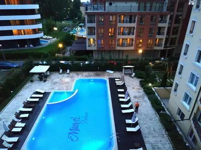 a swimming pool with lounge chairs next to a building at Marvel Delux Private Studio in Sunny Beach