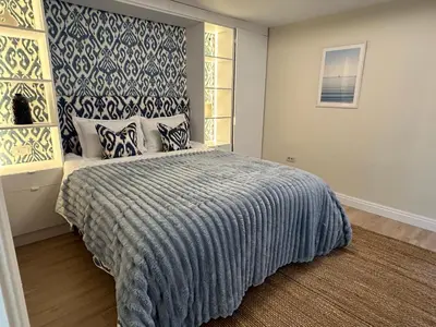 a bedroom with a bed with a blue and white bedspread at Apartment Hristo in Pomorie