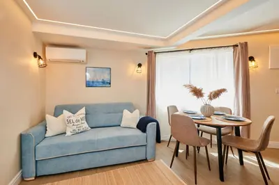 a living room with a blue couch and a table at Apartment Ivan in Pomorie