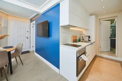 a kitchen with a blue wall and a table at Apartment Ivan in Pomorie