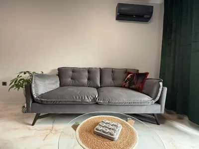 a grey couch in a living room with a table at Tea'S Apartment in Varna City