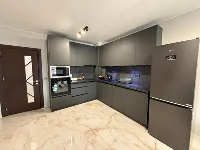 a large kitchen with gray cabinets and appliances at Tea'S Apartment in Varna City