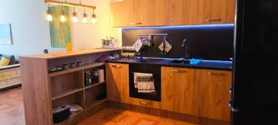 a kitchen with wooden cabinets and a sink at Sun Wave Apartment near the Sea in Sveti Vlas