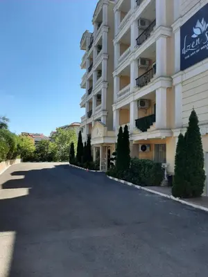 a large white building with trees in front of it at Villa Sardinia Sveti Vlas Studio in Sveti Vlas