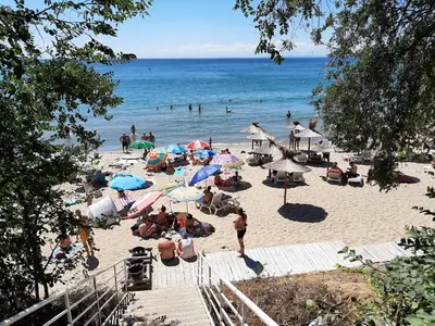 a group of people on a beach with umbrellas at Villa Sardinia Sveti Vlas Studio in Sveti Vlas