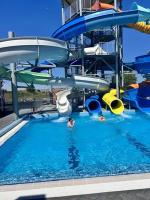 a group of people in a water slide in a pool at Sea Home in Sunny Beach
