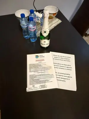 a table with a menu and bottles of water on it at Sea Home in Sunny Beach