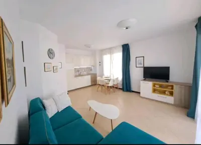 a living room with a blue couch and a television at Top Oasis Park Lozenets apartment in Lozenets