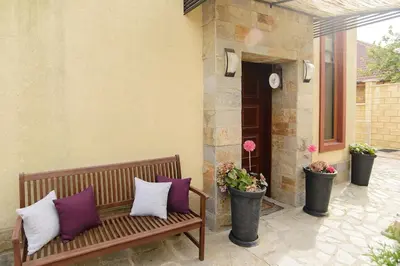 a wooden bench with three pillows on a patio at Villa SeaBreeze in Varna City