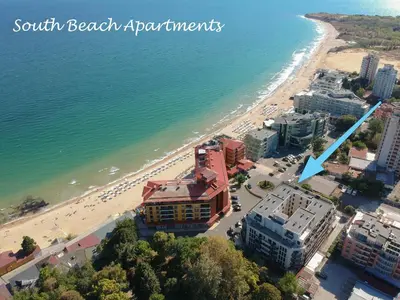 an aerial view of a beach with a building and the ocean at South Beach Apartment in Nesebar