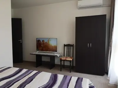a bedroom with a bed and a desk with a laptop on it at South Beach Apartment in Nesebar